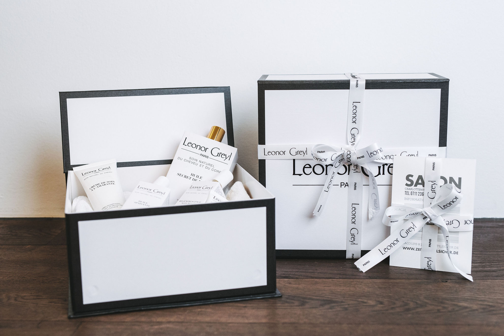 Leonor Greyl Produkte Geschenkbox mit Pflegeprodukten und La Coupe Visitenkarte mit Schleife